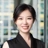 Jennifer Zhu in modern office, with glass panels, and a softly blurred workspace behind.