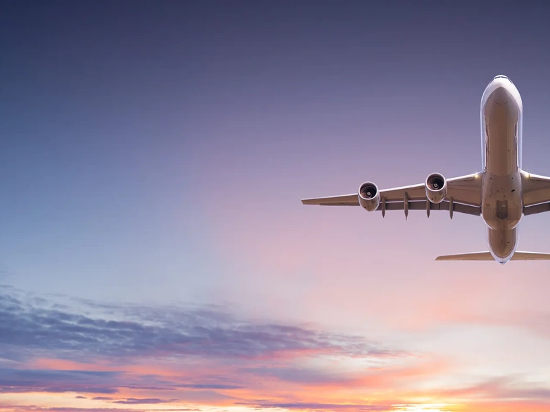 Commercial airplane jetliner flying above dramatic clouds in beautiful sunset light. Travel concept.