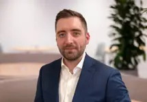 Portrait of Paul Barry, Data Centre Sector Lead, NAM, standing in plant based office in blue blazer.