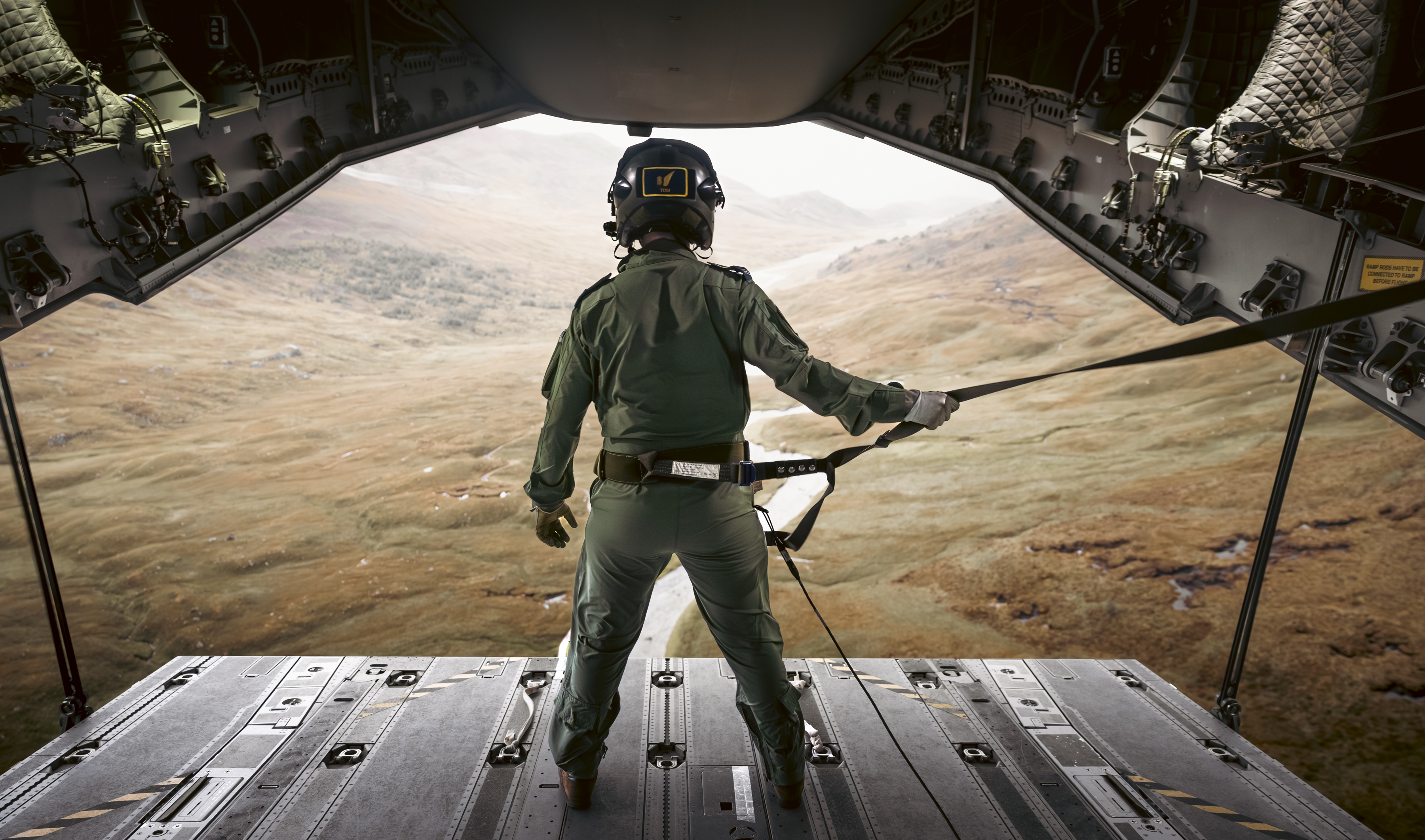 An RAF Atlas C.1 A400M Load Master looks out to the Cairngorm mountains whilst ramp riding during a low level training sortie through the Scottish Highlands.