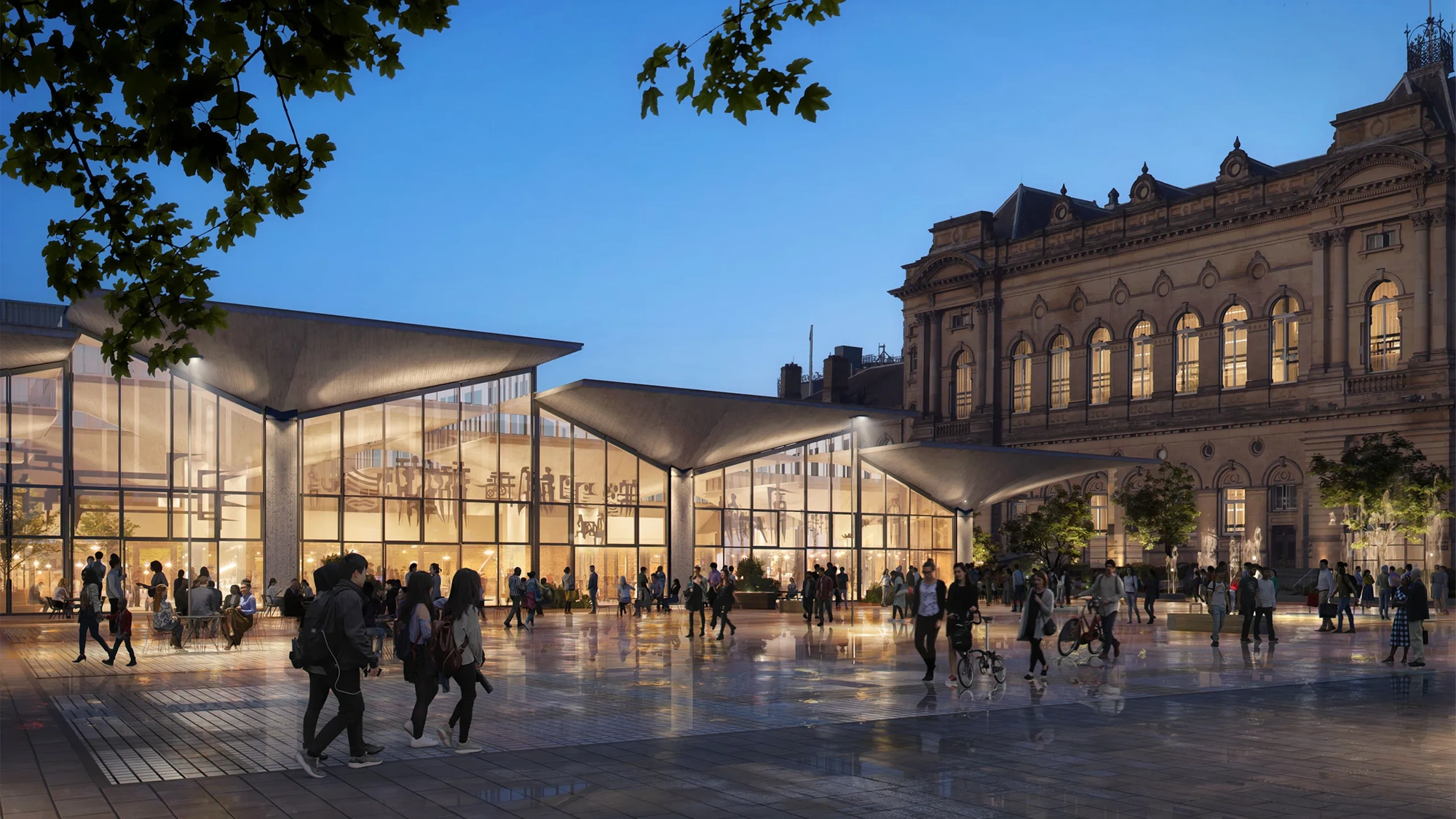 Modern glass-fronted pavilion with angular roofiines illuminated at dusk, set beside a historic stone building. People gather and walk across a reflective public square in front of the entrance.