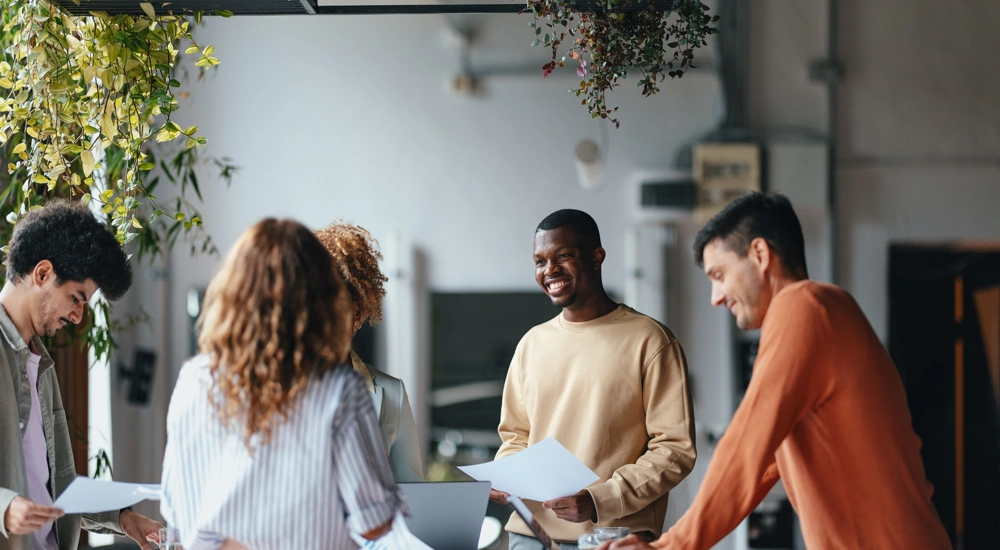 Diverse group of young people working in an office space with plants
