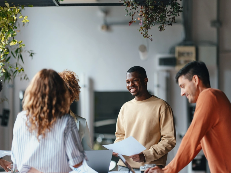 Diverse group of young people working in an office space with plants