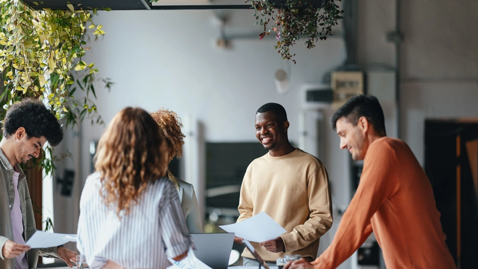 Diverse group of young people working in an office space with plants