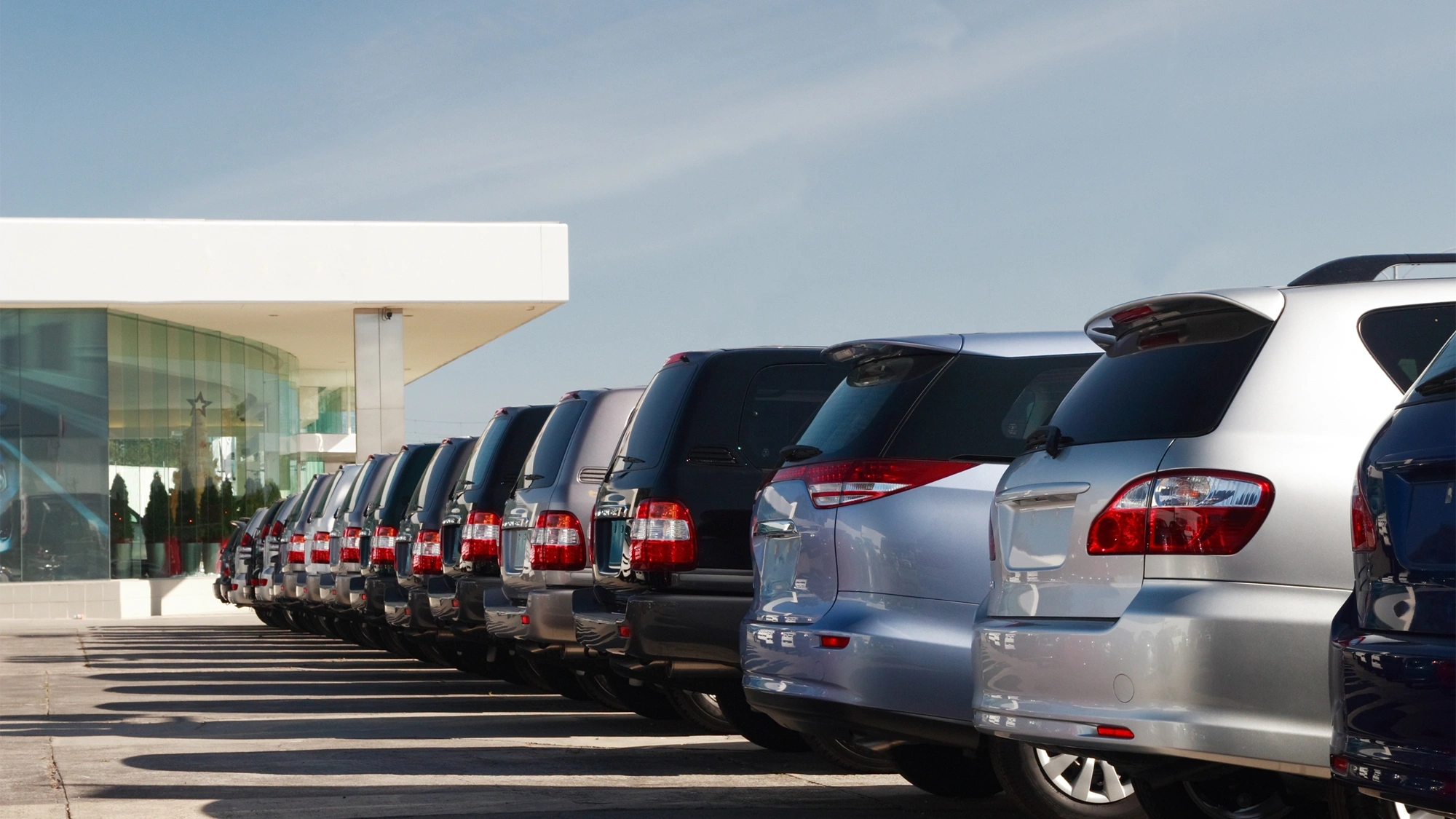 Cars parked up in a row in a car park, showing the back of the car.