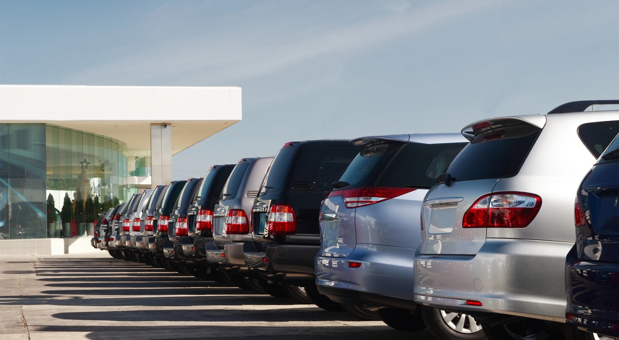 Cars parked up in a row in a car park, showing the back of the car.