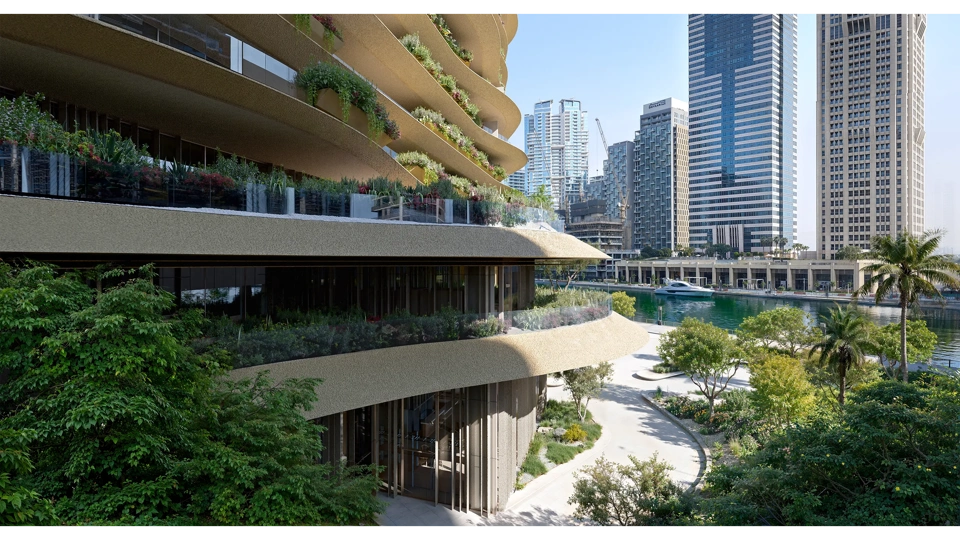 Modern curved building featuring greenery and city skyline in the background