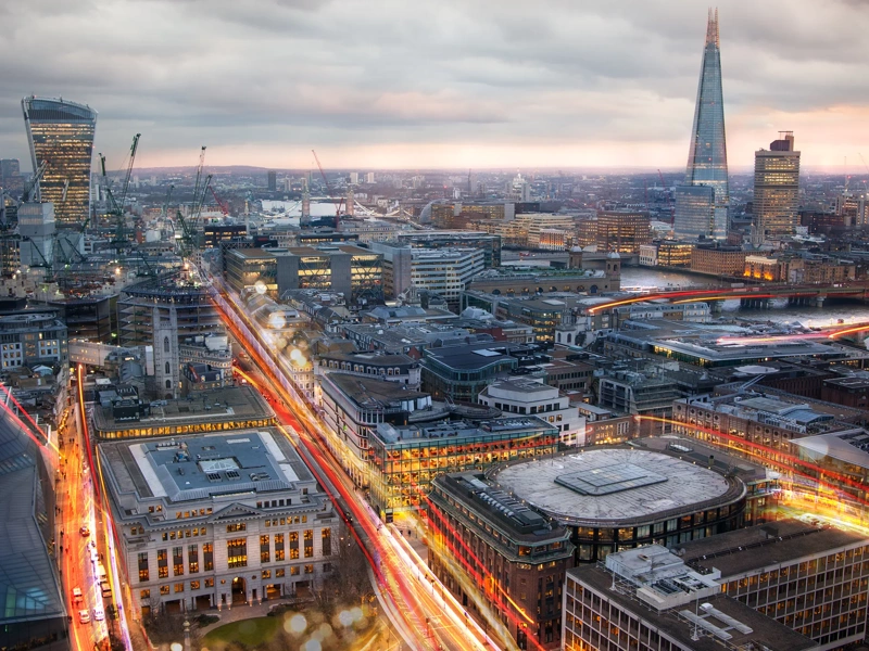 City of London view at sunset and busy road with transport blurred lights. Success, transformation and innovation idea.