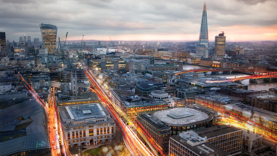 City of London view at sunset and busy road with transport blurred lights. Success, transformation and innovation idea.