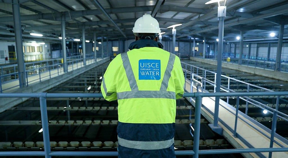 Uisce Éireann employee in high-vis jacket observes factory operations from raised platfrom, Ireland