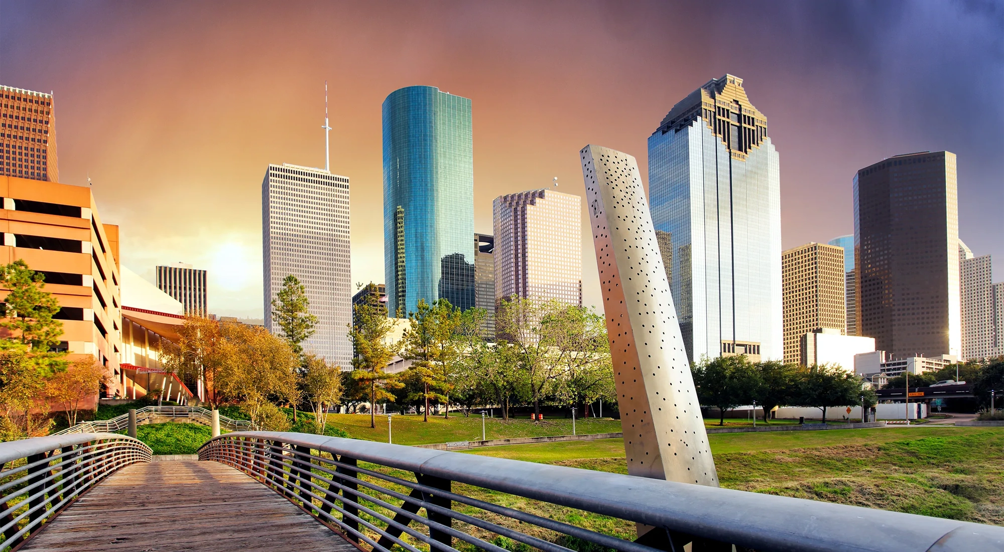 Collection of skyscrapers over a bridge at sunset