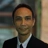 Portrait of Dargo Fitz Dinata, Director, Cost Management, Indonesia, outside in front of a blurred brown background featuring a building and mix of natural and urban elements.