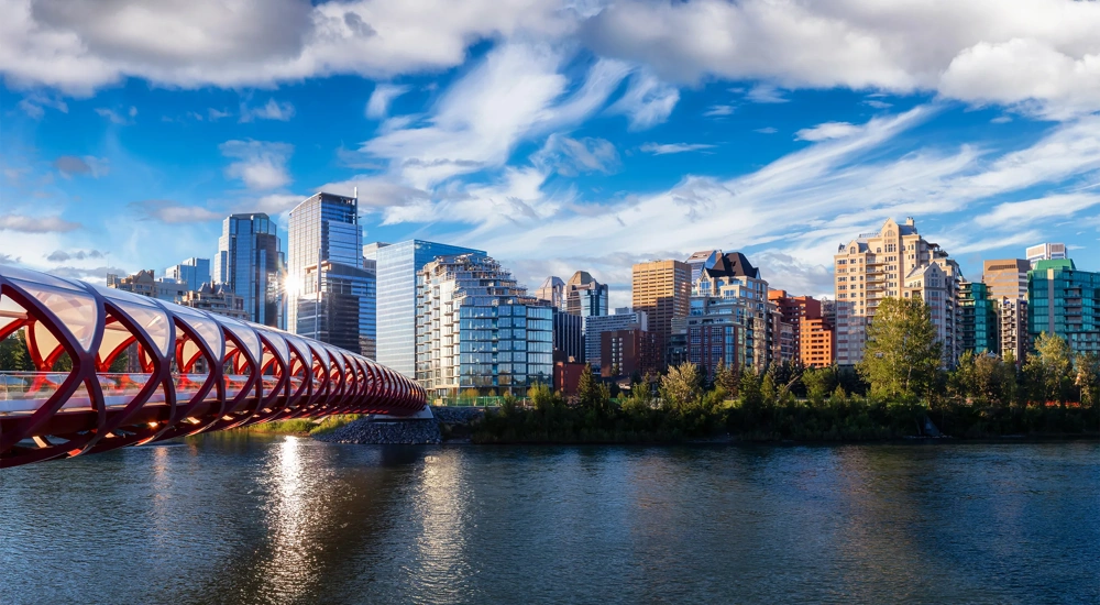 A beautiful sunrise sky over the Peace Bridge and the Bow river in the summertime.