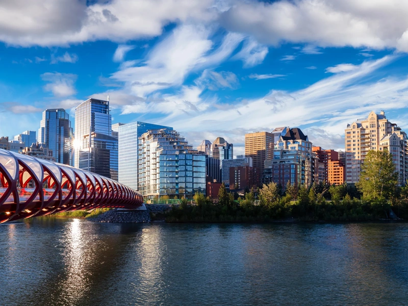 A beautiful sunrise sky over the Peace Bridge and the Bow river in the summertime.