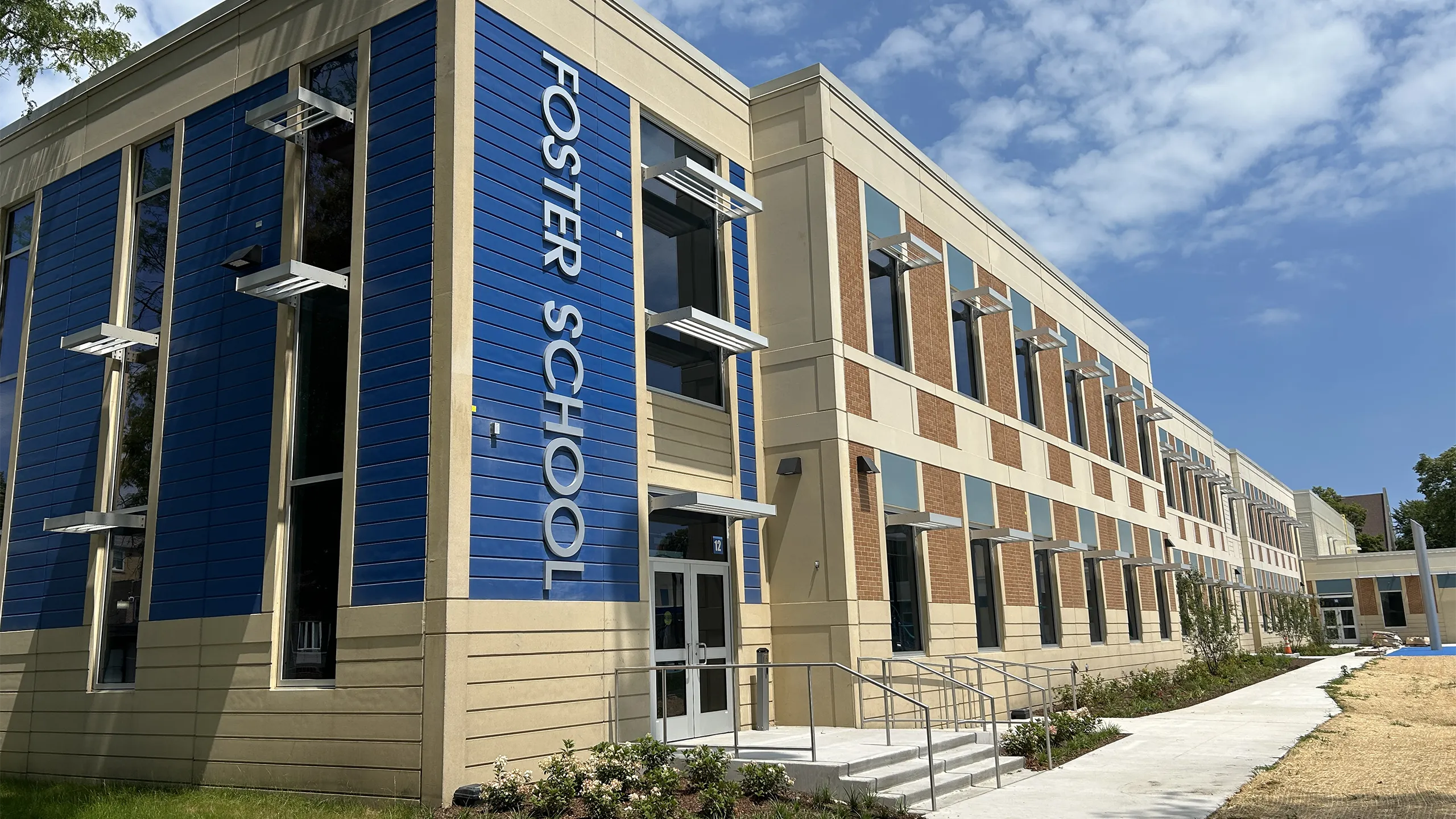A modern building with 'Foster School' on the side, during the daytime