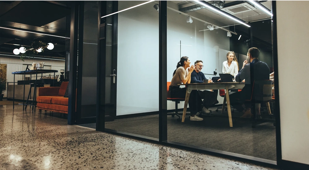 Coleagues sitting around a table in a meeting room