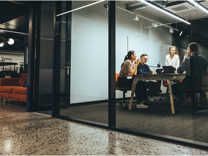 Coleagues sitting around a table in a meeting room