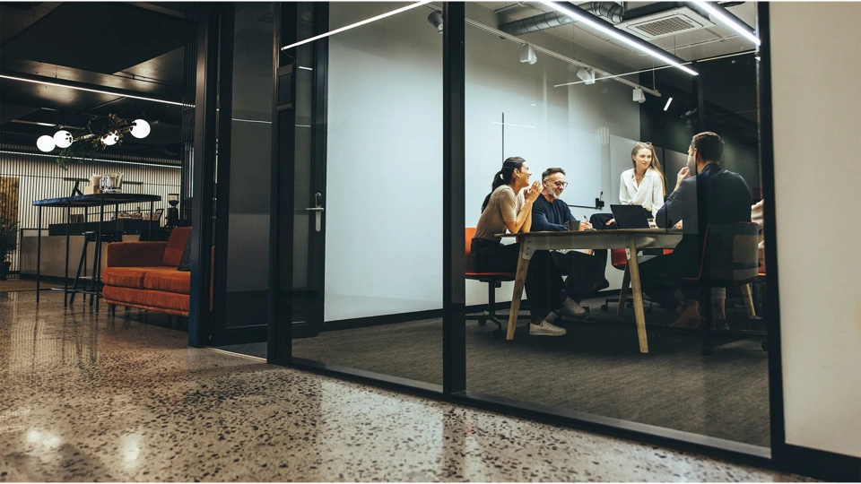 Coleagues sitting around a table in a meeting room