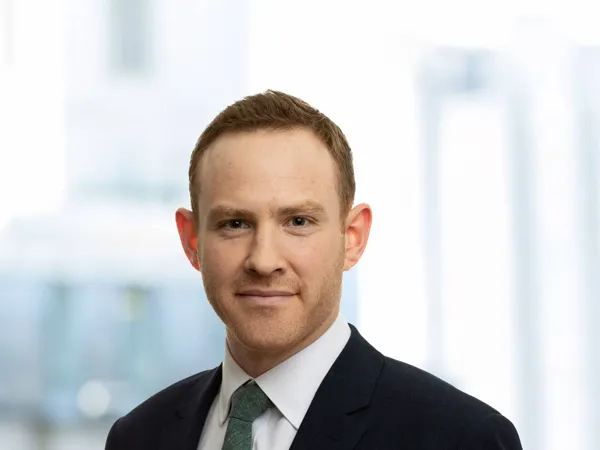 Portrait of Dave Carr, Associate Director, Corporate Occupier, UK, In black suit with green tie against window office.