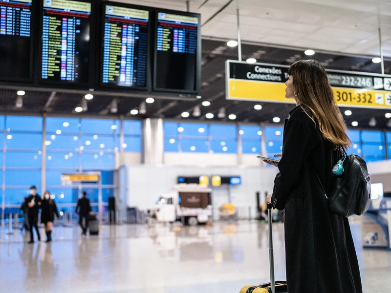 Portrait of a young woman using the mobile phone in the airport