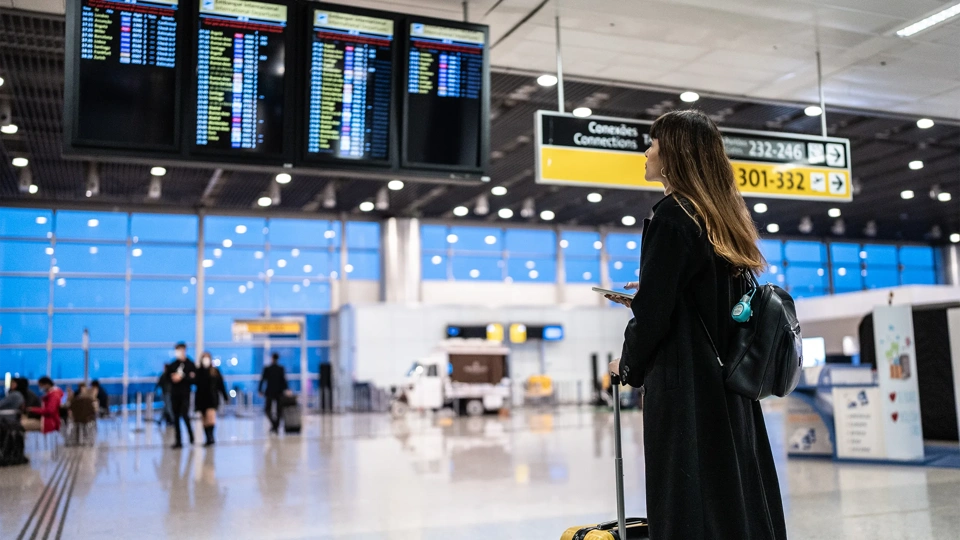 Portrait of a young woman using the mobile phone in the airport