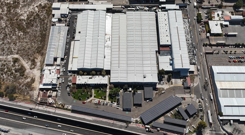 Aerial view of a large industrial facility in Balvanera, Mexico, showing multiple warehouse buildings, parking areas and nearby roads