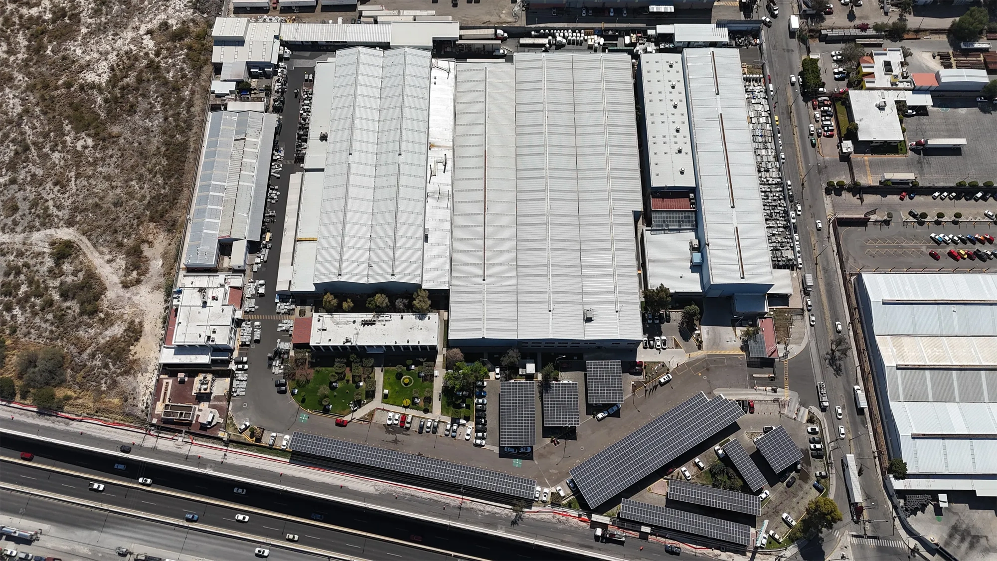 Aerial view of a large industrial facility in Balvanera, Mexico, showing multiple warehouse buildings, parking areas and nearby roads