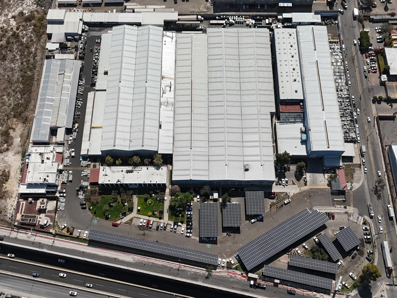 Aerial view of a large industrial facility in Balvanera, Mexico, showing multiple warehouse buildings, parking areas and nearby roads