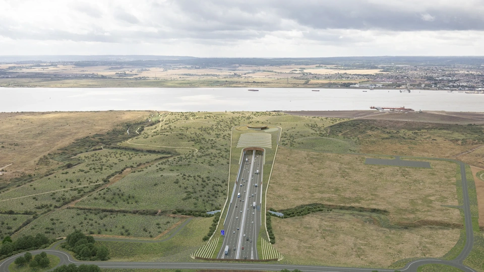 Portrait of highway surrounded by green fields and river.