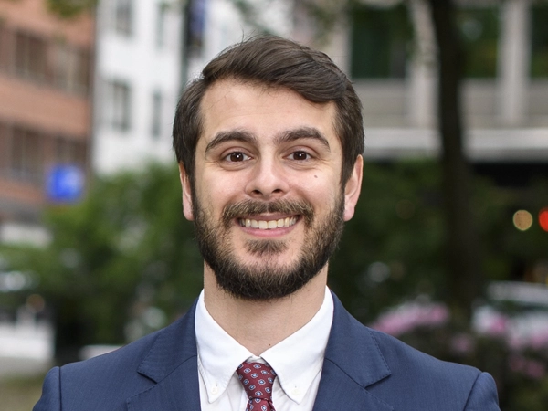 Portrait of Nima Aase, Managing Director, Scandinavia, outside in front street with trees and tall buildings,