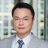 Tino Chang, Lead Director, with city landscape featuring building with lots of windows in the background.